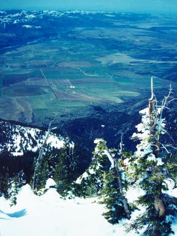 View westward to Swan Valley and the Weeks Ranch, with the Idaho Falls-Rigby area on the horizon. This is at the head of Baldy Couloir, 4/27/98. Photo by Rick Baugher.